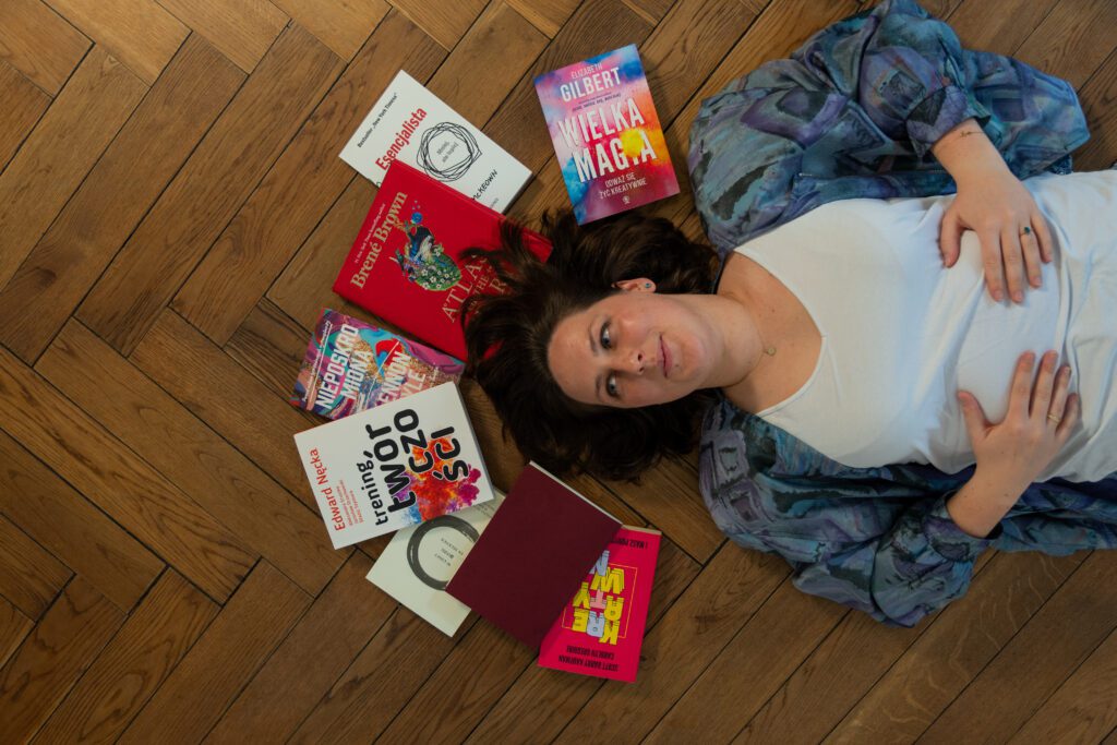 Leżąca kobieta otoczona książkami