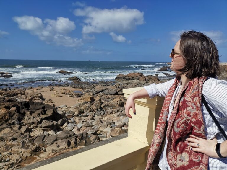 Kobieta nad oceanem myśląca o pułapce utopionych kosztów